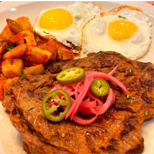 Desayuno de la Casa - House breakfast plate with eggs, beans, rice, tortillas, and fresh salsa.