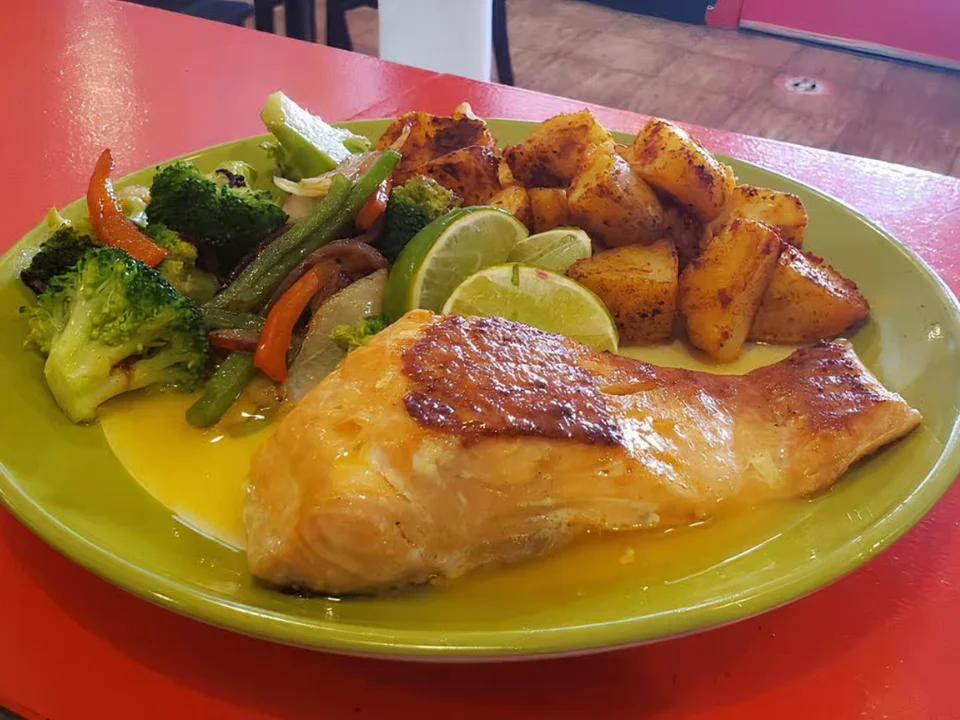 Grilled Salmon - Fresh grilled salmon served with Mexican-style rice and seasonal vegetables.